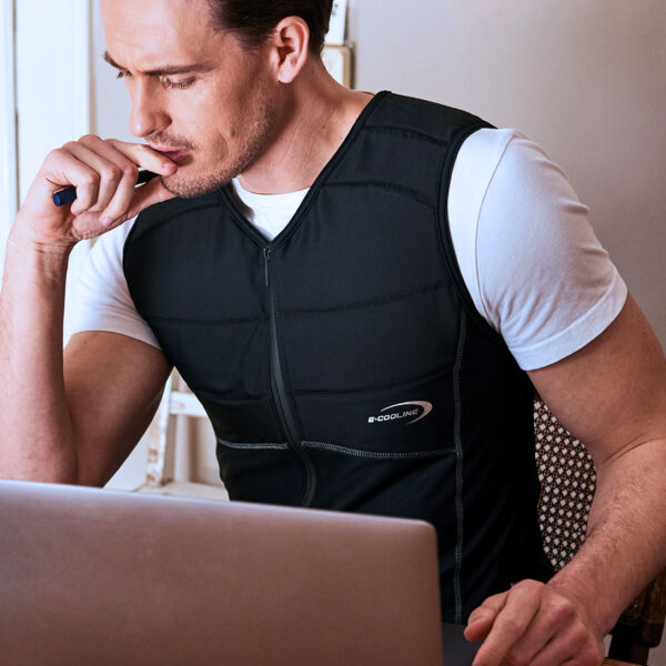 Man wearing cooling shirt from E.COOLINE in black and working on laptop
