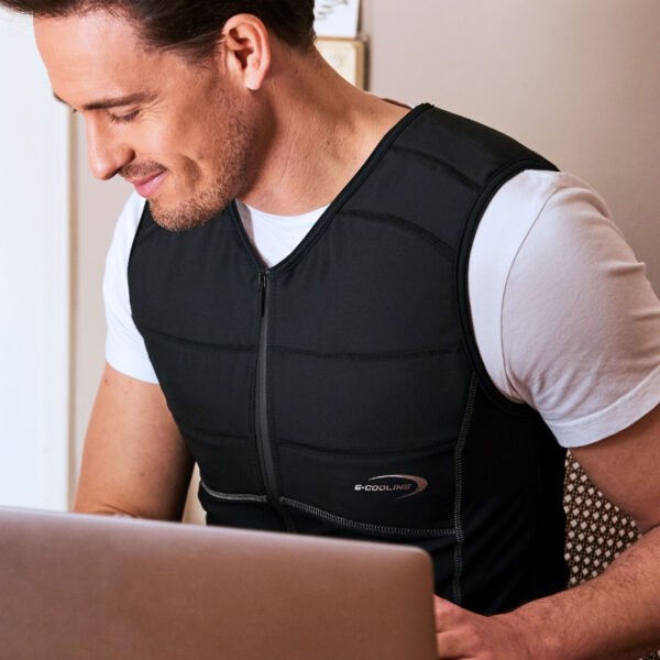 Man wearing cooling shirt from E.COOLINE in black and working on laptop